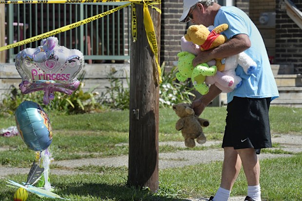 Paul Laughlin, 57, places stuffed animals outside the day care home in Pennsylvania, where five kids were killed in a fire.