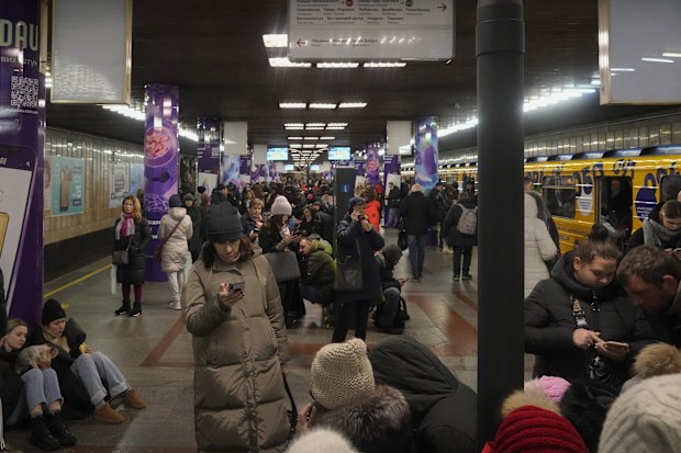 People rest in the subway station, being used as a bomb shelter during a rocket attack in Kyiv, Ukraine, Friday, Dec. 16, 2022. 
