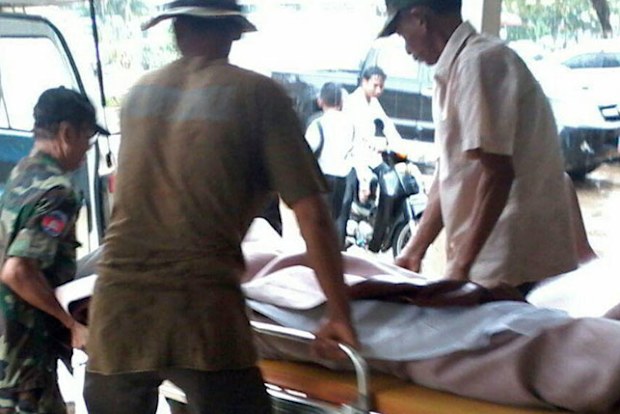 In this photo from Cambodia National Police, men help carry an unidentified individual on a gurney at the local provincial hospital of Kampong Speu province