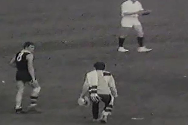 Molly Meldrum approaches a St Kilda player after running onto the field.