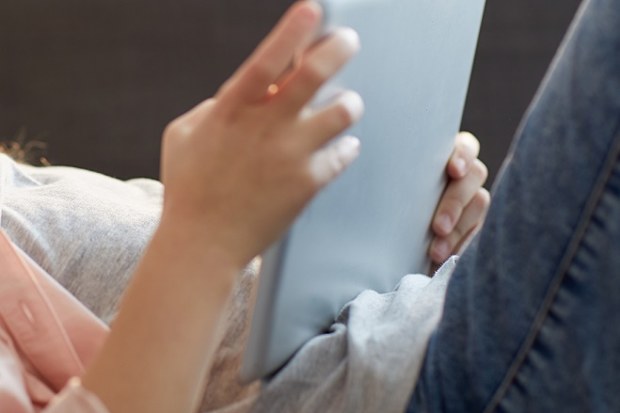 Girl using iPad on lounge