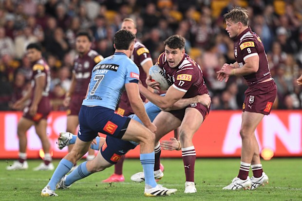 Trent Loiero attempts to evade the Blues defensive line as he runs the ball for Queensland.