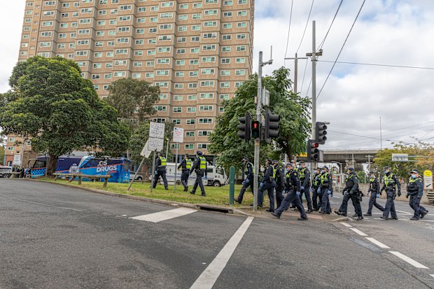 Protective service police officers walk towards the Flemington Public housing flats