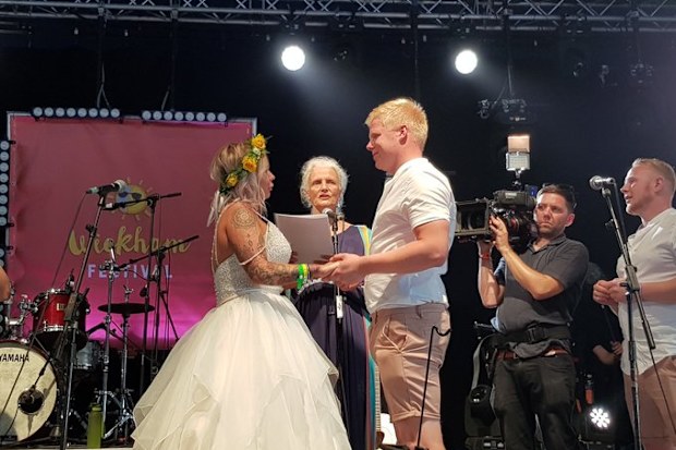 The couple saying their vows on the festival stage