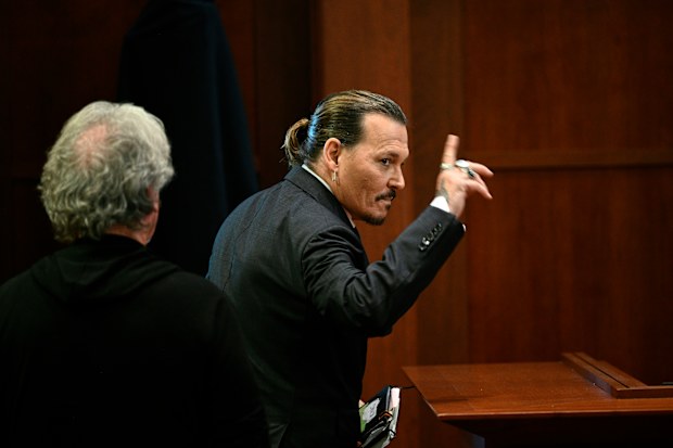 Actor Johnny Depp gestures as he walks out of the courtroom during a break at the Fairfax County Circuit Courthouse in Fairfax, Va., Tuesday, May 17, 2022. 