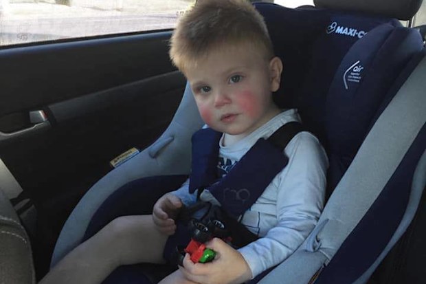 Spencer McPherson in his car seat on the way to hospital.