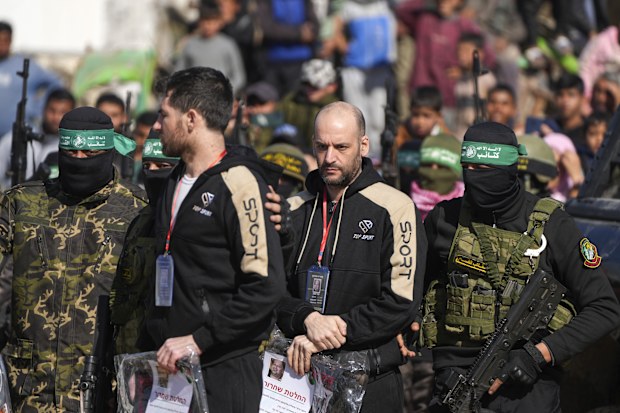 Hostages Iair Horn, 46, Israeli-Argentine, center, and Sagui Dekel Chen, 36, left, Israeli-American are escorted by Hamas and Islamic Jihad fighters before being handed over to the Red Cross in Khan Younis, Gaza Strip, Saturday, Feb. 15, 2025. (AP Photo/Abdel Kareem Hana)