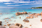 Woman wearing stylish bikini enjoying swimming and snorkeling at amazing Anse Lazio beach on Praslin Island, Seychelles. Summer vacations on picture perfect tropical beach concept.�