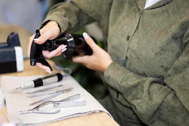 Manicurist making nail manicure instruments disinfection process. Professional manicure treatment in beauty salon. Hygiene and care in beauty industry.