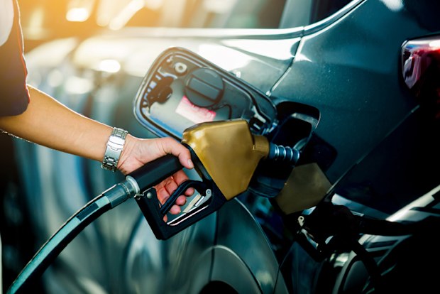 Hand refilling the car with fuel at the refuel station,  the concept of fuel energy