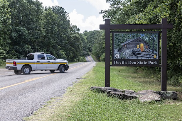 An Arkansas Park Ranger patrols the South Entrance of Devils Den State Park Monday, July 28, 2025, in West Fork, Ark. Police in Arkansas are searching for a suspect in the deaths of a couple who investigators said were attacked while on a wooded walking trail with their two young daughters.  (AP Photo/Michael Woods)