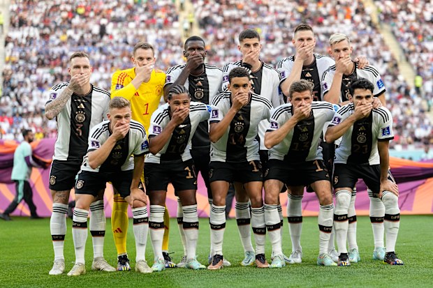 Players from Germany pose for the team photo as they cover their mouth during the World Cup group E soccer match between Germany and Japan, at the Khalifa International Stadium in Doha, Qatar, Wednesday, Nov. 23, 2022.