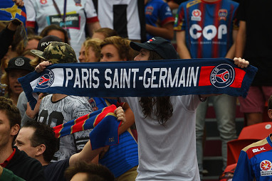Another fan holds aloft a scarf for Parisian club Paris Saint-Germain.