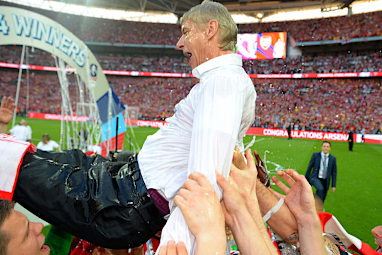 Drowning in delight. A drenched Wenger is thrown into the air by his players.