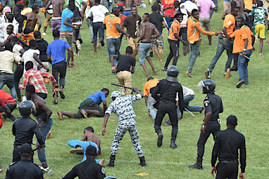 A policeman appearing to strike a supporter with a baton.