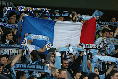 The French flag is held high in the crowd during an A-League in Sydney.