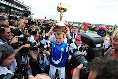 Jockey Ryan Moore raises the cup triumphantly. (AAP)