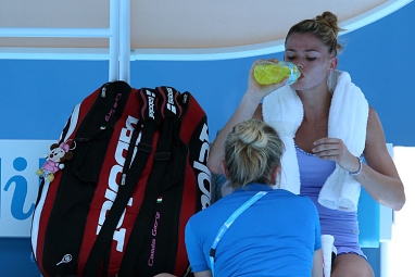 Camila Giorgi gets some help from a trainer. (AAP)