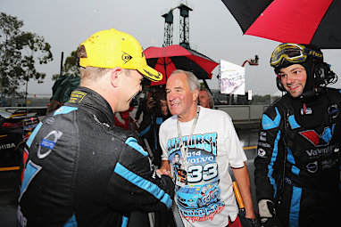 Even the pitlane crews were forced to grab umbrellas. (Getty)