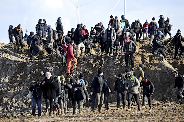  Activists and coal opponents walk along the demolition edge of the Garzweiler II opencast lignite mine during a protest by climate activists after the clearance of Luetzerath, with police officers standing in between in Erkelenz, Germany, Tuesday, Jan. 17, 2023.  