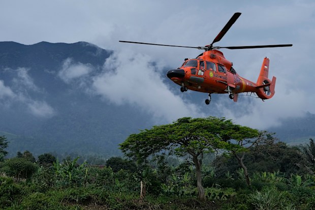 Members of the National Search and Rescue Agency (BASARNAS) flies a helicopter to deliver relief goods to a village affected by Monday's earthquake in Cianjur, West Java, Indonesia, Saturday, Nov. 26, 2022. 