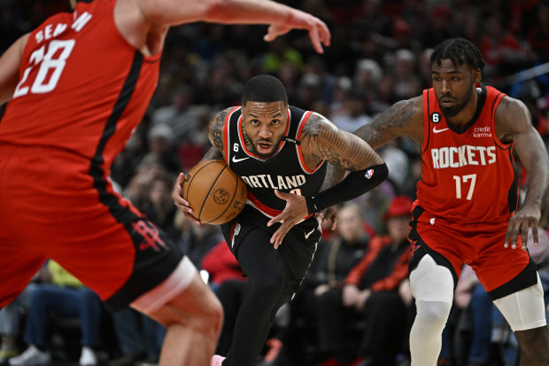 PORTLAND, OREGON - FEBRUARY 26: Damian Lillard #0 of the Portland Trail Blazers drives to the basket against Tari Eason #17 and Alperen Sengun #28 of the Houston Rockets during the first quarter at the Moda Center on February 26, 2023 in Portland, Oregon. NOTE TO USER: User expressly acknowledges and agrees that, by downloading and or using this photograph, User is consenting to the terms and conditions of the Getty Images License Agreement. (Photo by Alika Jenner/Getty Images)