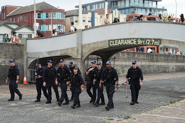 Security officers sweep an area at Bondi Beach in Sydney, Sunday, Dec. 21, 2025, ahead of a ceremony to mark the National Day of Reflection for victims and survivors from the Bondi shooting on Dec. 14.