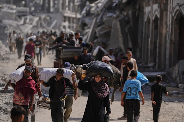 Displaced Palestinians walk along the coastal road as they move in the direction of Gaza City,