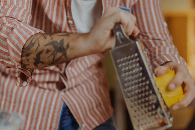 man grating cheese