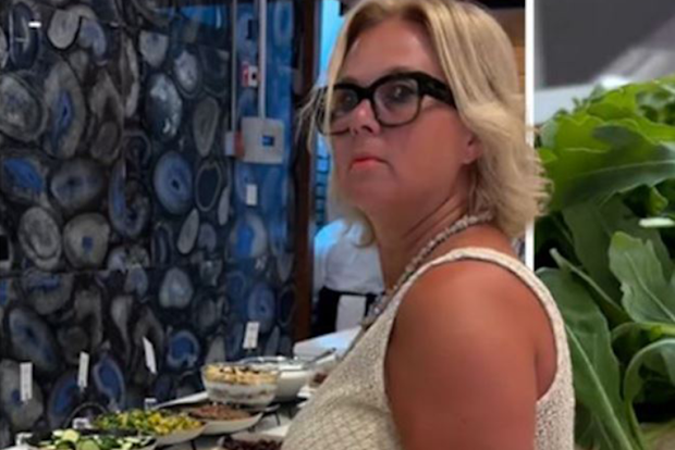 woman packs lunch from hotel breakfast buffet