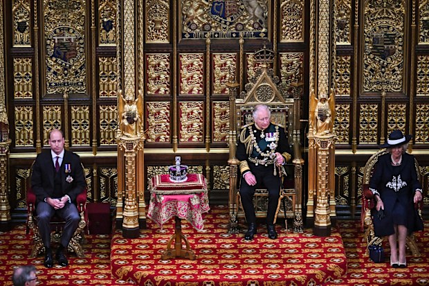 Prince Charles, Prince of Wales (2nd R) sits by the The Imperial State Crown (2nd L) with Britain's Prince William, Duke of Cambridge (L) and Britain's Camilla, Duchess of Cornwall (R) in the House of Lords Chamber, during the State Opening of Parliament, in the Houses of Parliament, in London, on May 10, 2022.