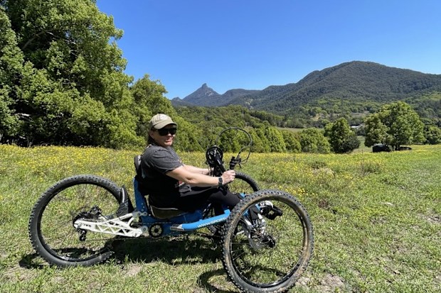 Ashlee Morton biking on a grassy hill.