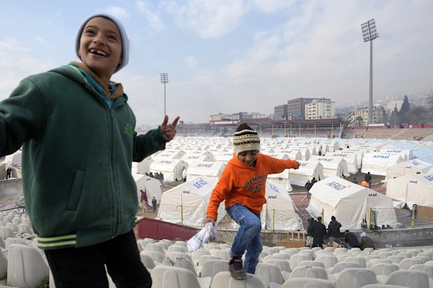 Children play at a stadium where tents have been setup to accommodate earthquake survivors, in Kharamanmaras, southeastern Turkey, Friday, Feb. 10, 2023.