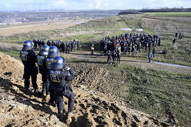 Police officers have surrounded a group of activists and coal opponents on the edge of the Garzweiler II lignite open pit mine during a protest by climate activists following the clearance of Luetzerath, Germany, Tuesday, Jan. 17, 2023.  