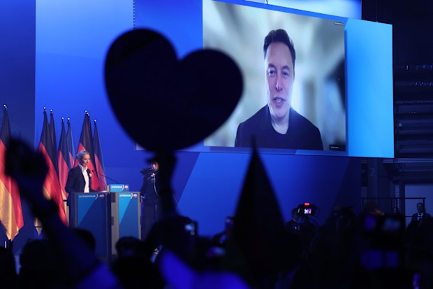 HALLE, GERMANY - JANUARY 25: Tech billionaire Elon Musk speaks live via a video transmission during a speech by Alice Weidel, chancellor candidate of the far-right Alternative for Germany (AfD) political party, at the AfD election campaign launch rally on January 25, 2025 in Halle, Germany. Musk is an outspoken supporter of the AfD and is urging German voters to cast their ballots for the party. The AfD is currently in second place in polls ahead of federal parliamentary snap elections scheduled