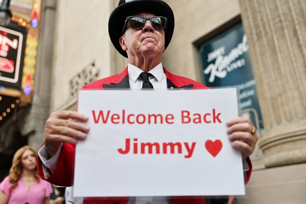 LOS ANGELES, CALIFORNIA - SEPTEMBER 23: Gregg Donovan displays a "Welcome Back Jimmy" sign outside the El Capitan Entertainment Centre in Hollywood where the "Jimmy Kimmel Live!" show will be recorded on the first night of the show's return to the ABC lineup on September 23, 2025 in Los Angeles, California. Kimmel's ABC late-night show is returning tonight after being suspended following controversy over his comments about the suspected shooter of Charlie Kirk. (Photo by Mario Tama/Getty Images)