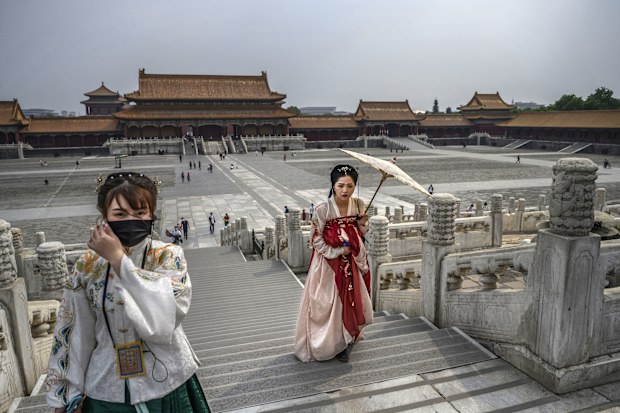 Chinese women dressed in traditional costume known as Hanfu tour the Forbidden City, which recently re-opened to limited visitors, in Beijing, China