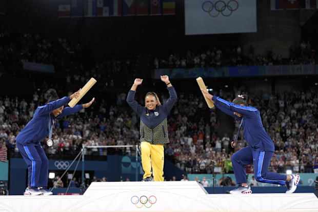 Silver medalist Simone Biles, of the United States, left, and bronze medalist Jordan Chiles, of the United States, right, bow to gold medalist Rebeca Andrade, of Brazil, 