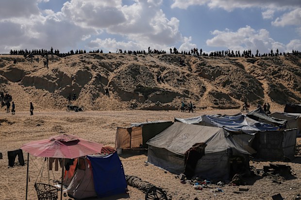 Displaced Palestinians walk along the coastal road near Wadi Gaza in the central Gaza Strip