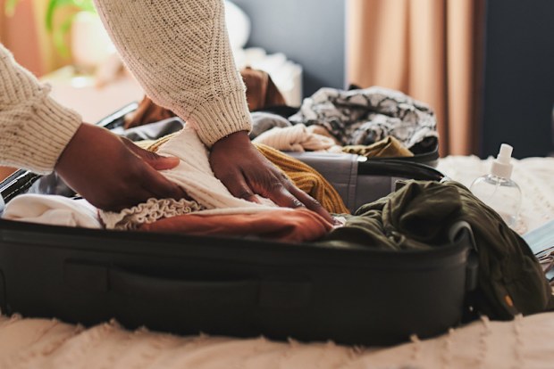 I can't leave this behind woman packing suitcase