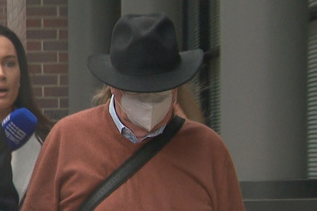 An ex-priest allegedly caught trying to procure a 14-year-old boy for sex online in a police sting a week before Christmas left court wearing an Akubra-style hat and face mask. Guy Norman Hartcher did not answer questions as he pushed his way through waiting journalists outside the court.