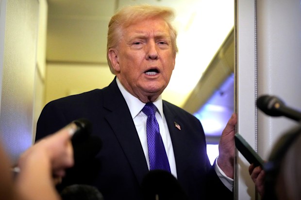 President Donald Trump speaks to reporters as he flies aboard Air Force One from Joint Base Andrews, Md., to West Palm Beach, Fla., Friday, Feb. 6, 2026 (AP Photo/Mark Schiefelbein)