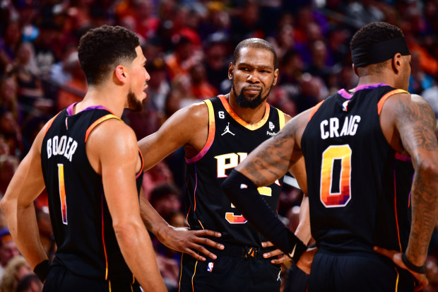 PHOENIX, AZ - APRIL 16:  Devin Booker #1, Torrey Craig #0, & Kevin Durant #35 of the Phoenix Suns looks on during the game During round one game one of the 2023 NBA Playoffs on April 16, 2023 at Footprint Center in Phoenix, Arizona. NOTE TO USER: User expressly acknowledges and agrees that, by downloading and or using this photograph, user is consenting to the terms and conditions of the Getty Images License Agreement. Mandatory Copyright Notice: Copyright 2023 NBAE (Photo by Barry Gossage/NBAE 