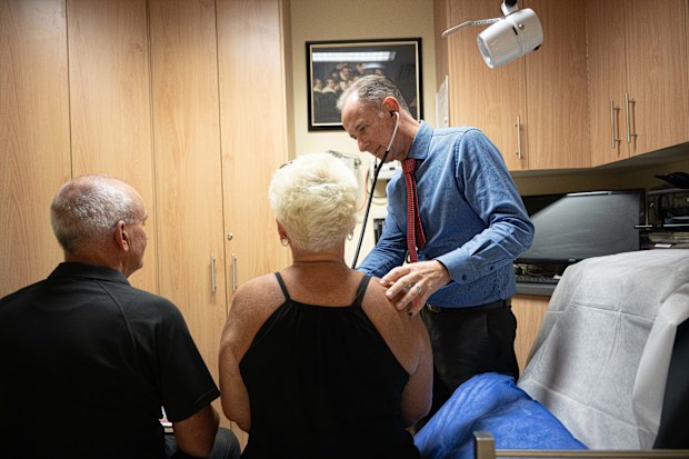 A GP during an appointment with two patients.
