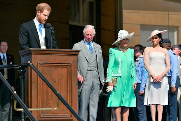 The Prince of Wales, the Duchess of Cornwall and the Duchess of Sussex, listen as the Duke of Sussex speaks during a garden party at Buckingham Palace in London.