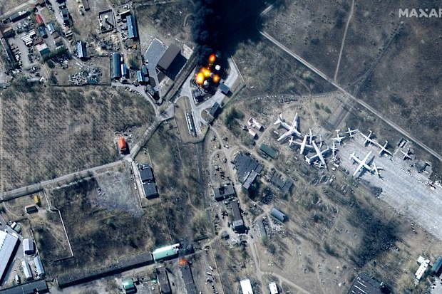 This multispectral satellite image provided by Maxar Technologies shows buildings and fuel storage tanks on fire at Antonov Airport, during the Russian invasion, in Hostomel, Ukraine, Friday, March 11, 2022. (Satellite image ©2022 Maxar Technologies via AP)