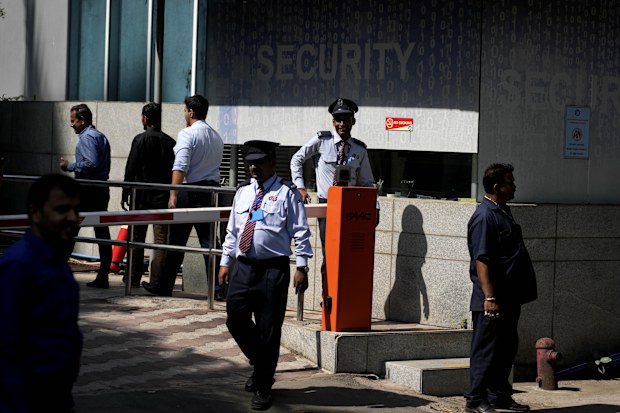 Private security guards stand outside a building housing BBC office, in Mumbai, India, Tuesday, Feb. 14, 2023. 