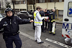 Firefighters carry an injured man on a stretcher in front of the offices of the French satirical newspaper Charlie Hebdo. (Getty)