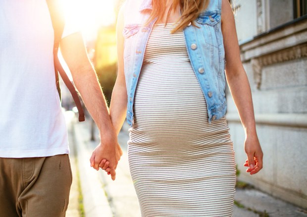 Man walking hand in hand with pregnant partner