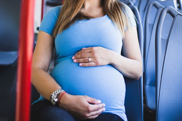 Pregnant woman sitting on bus